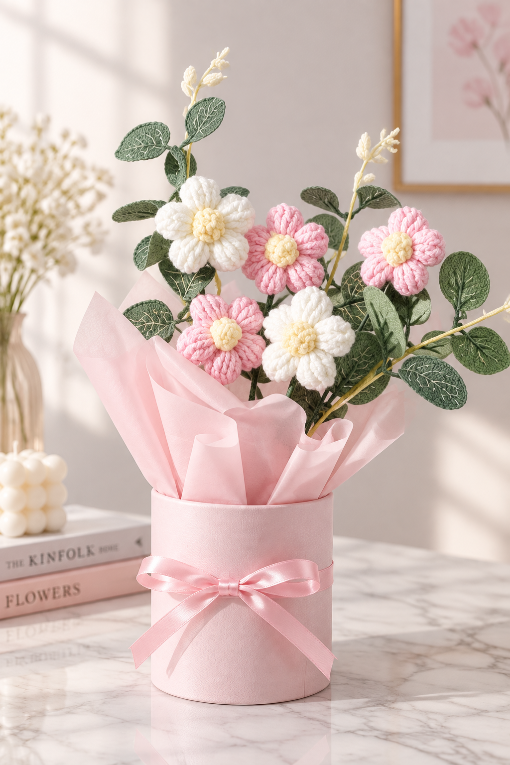 Pink and white crochet flower bouquet in pink ribbon vase on white marble
