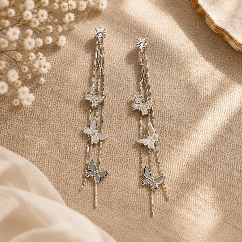 Silver butterfly drop earrings flat lay on linen