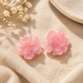 Pink flower cluster stud earrings on beige linen