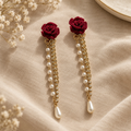 Red rose pearl tassel drop earrings on linen flat lay