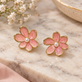 Pink enamel pearl flower earrings on marble surface